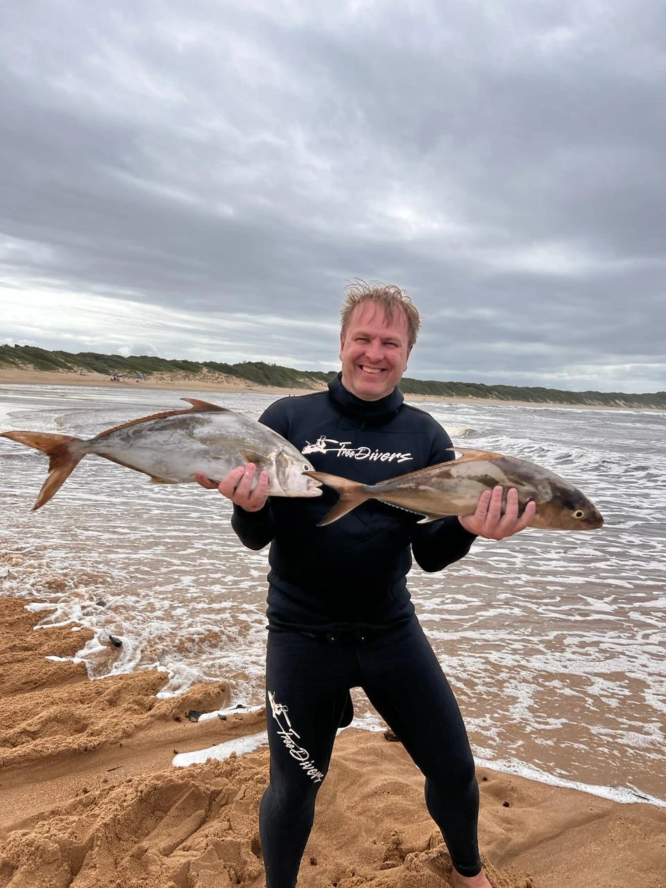 Spearfisher holding two caught fish